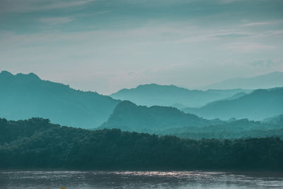 Scenic view of sea and mountains against sky