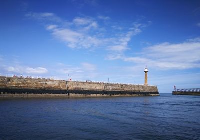 Tower bridge over sea against blue sky