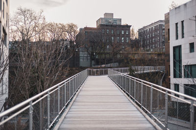 Rear view of woman walking on footbridge