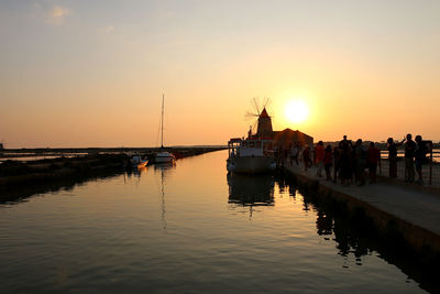 Boats in sea against sky during sunset