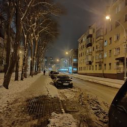 Cars on road in city at night during winter