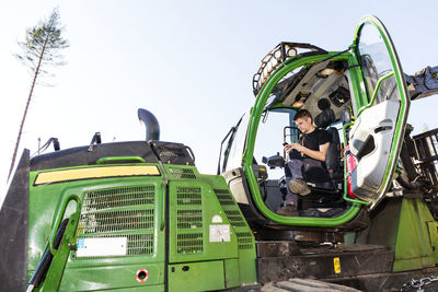 Man sitting in forest machine