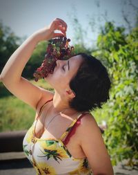 Side view of young woman holding flower bouquet