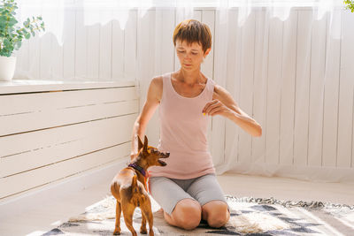 Woman practicing exercising with dog to enjoying and relaxing with yoga. spend