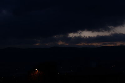 Scenic view of silhouette mountain against sky at night