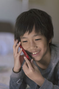 Close-up of happy boy talking on mobile phone