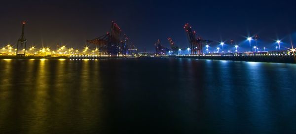 Illuminated bridge over river at night