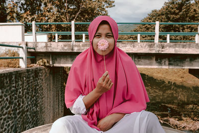 Portrait of smiling woman sitting outdoors