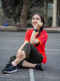 Smiling teenage girl sitting outdoors