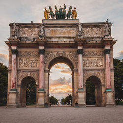 Triumphal arch of the tuileries gardens at sunset in paris france