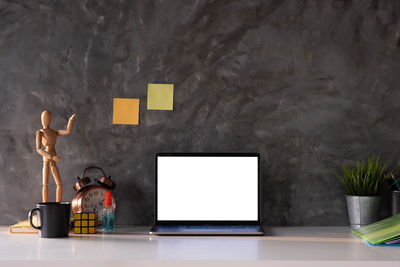 Man and coffee cup on table against wall at home