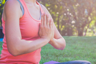 Midsection of woman sitting on field