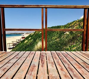 Close-up of wooden window with sea in background