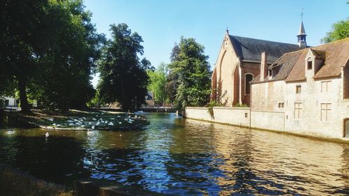 River amidst trees and buildings against sky