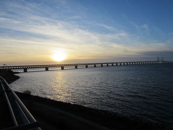 Bridge over sea at sunset