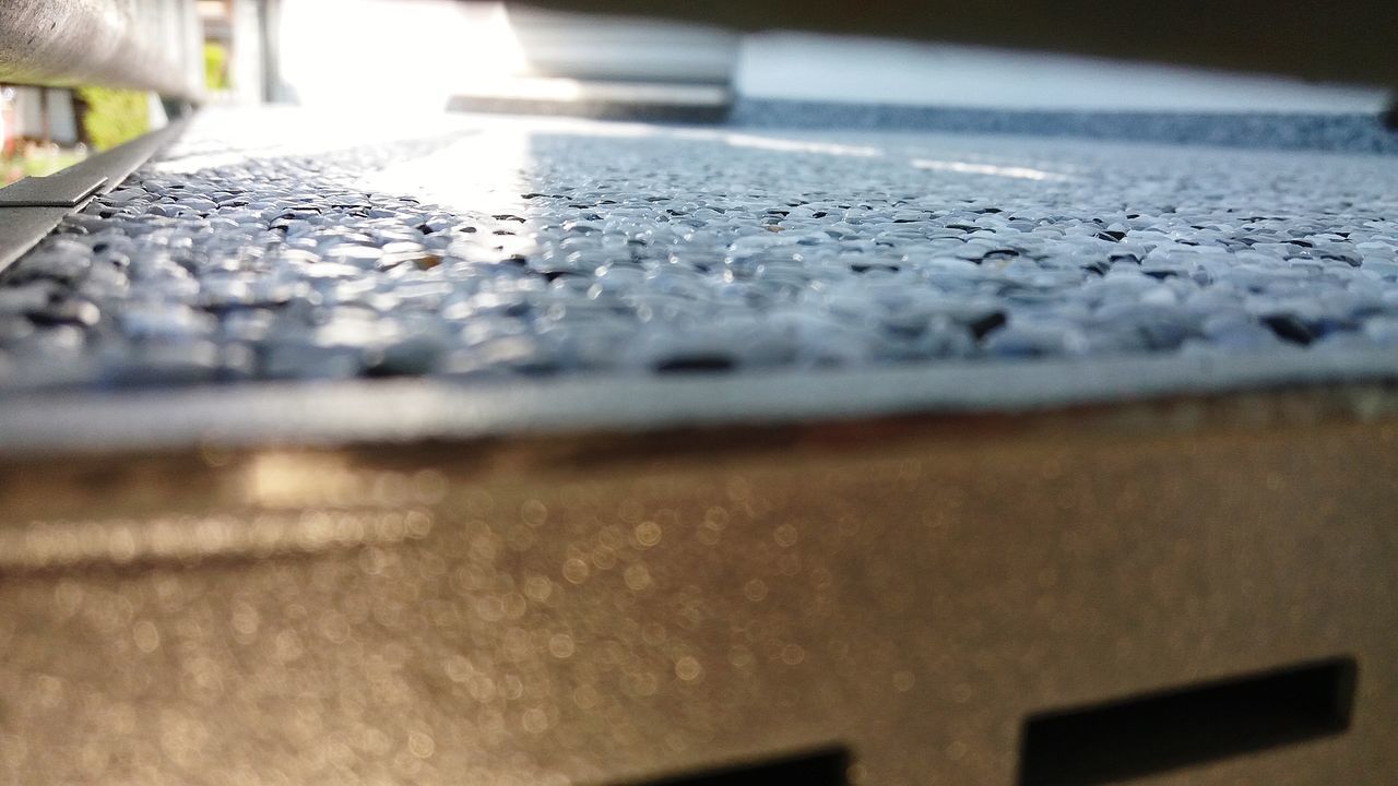 SURFACE LEVEL OF FOOTPATH BY METAL GRATE ON WOOD