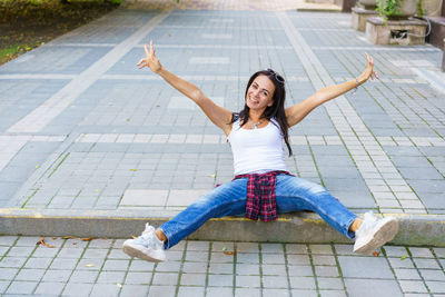 Portrait of young beautiful brunette woman with long hair in blue jeans