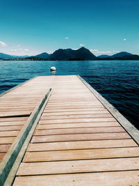 Pier on lake against blue sky