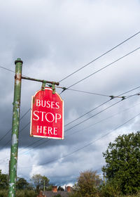 Low angle view of road sign against sky