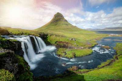 Scenic view of waterfall against sky