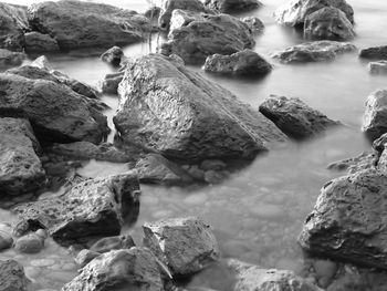 Rocks at beach against sky