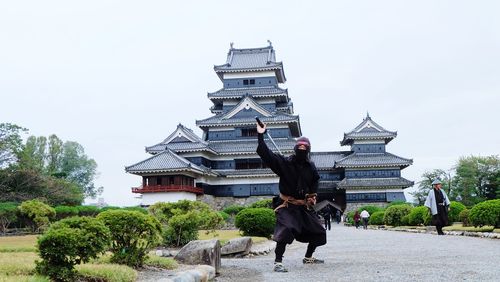 Full length of man standing by building against sky