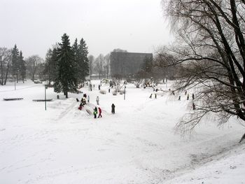 People on snow covered landscape against sky