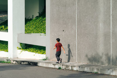 Rear view of man walking on footpath