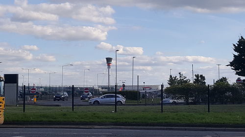 Cars on road against cloudy sky