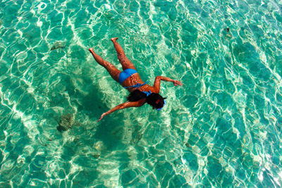 High angle view of woman wearing bikini snorkeling in sea