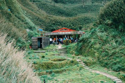 Crowd of people by built structure against forest