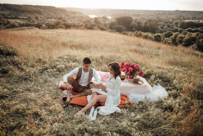 Couple sitting on land by plants