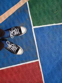 Low section of person on colorful floor