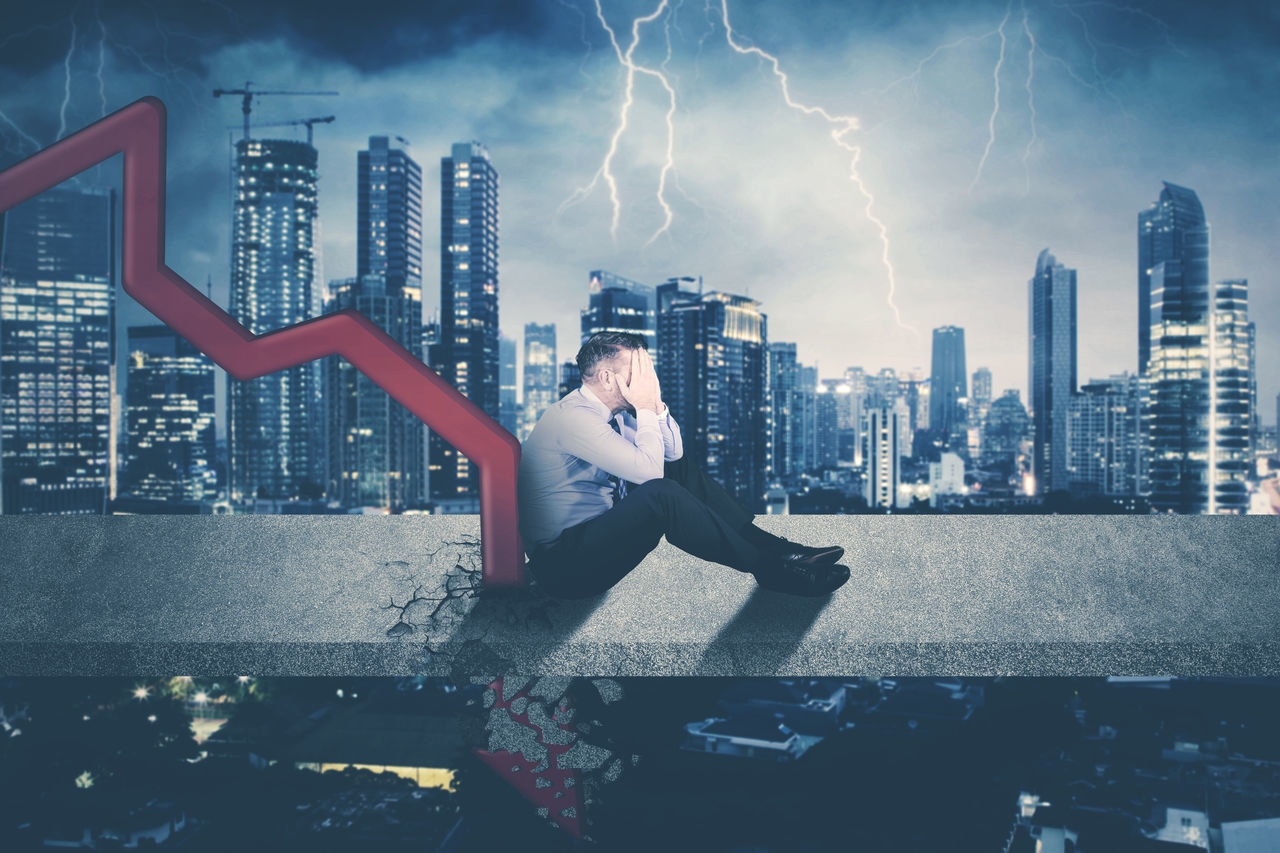 MAN AND BUILDINGS AGAINST SKY IN CITY