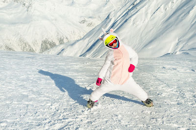 Full length of girl enjoying in snow covered land