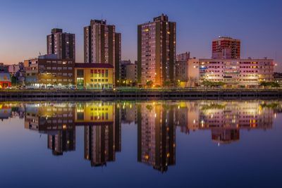 Illuminated buildings with reflection on lake at night
