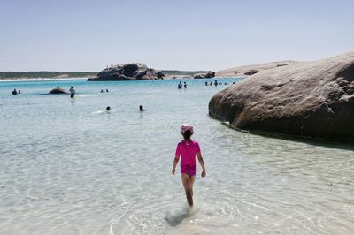 Woman standing on beach against clear sky