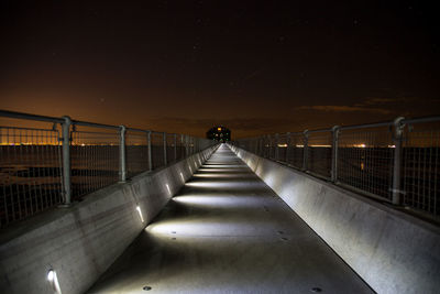 Rear view of man on footbridge at night