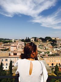 Rear view of woman with cityscape in background