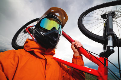 Wide angle vertical frame top angle. portrait of a bearded mountain biker with his bicycle against a