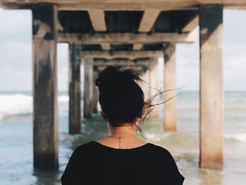 Rear view of woman under pier