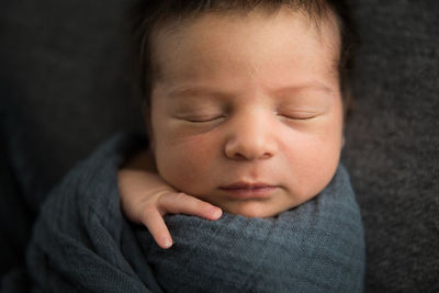 Close up view of sleeping newborn baby's face, lots of hair