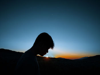 Silhouette man standing against sky during sunset