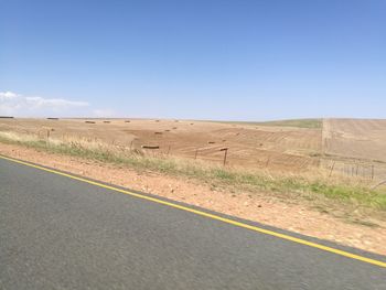 Road by landscape against clear sky