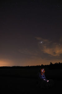 Light games with redhead woman at night with a subtle starry sky