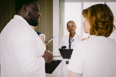 Team of multiracial medical discussing while standing at hospital