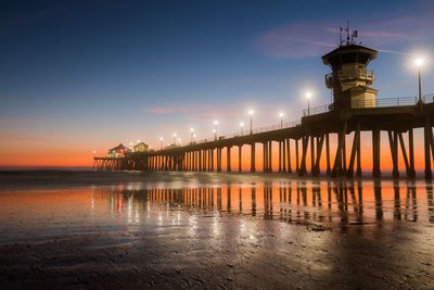 View of lighthouse at seaside during sunset