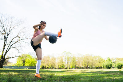 Full length of woman playing with soccer ball in park
