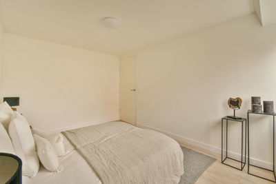 Rear view of woman sitting on bed at home