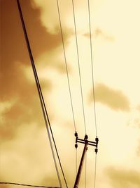 Low angle view of silhouette electricity pylon against sky